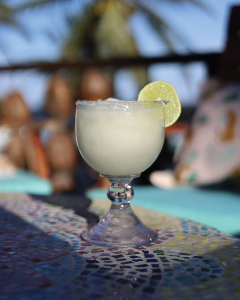 A frozen margarita on a mosaic table at the beach
