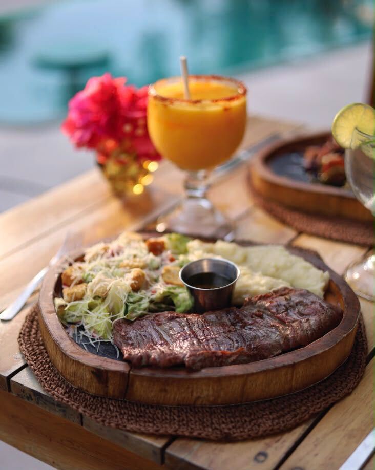 A steak dinner with a mango margarita by the pool