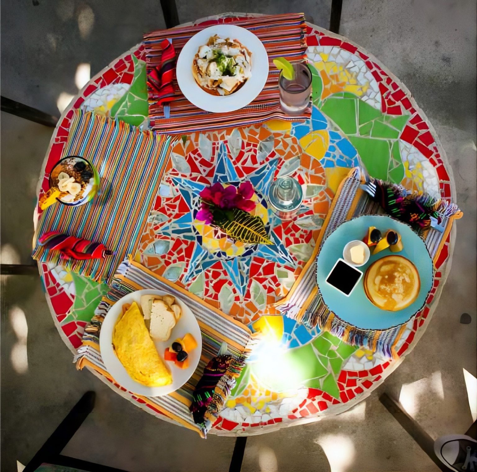 A mosaic table laid with breakfast dishes