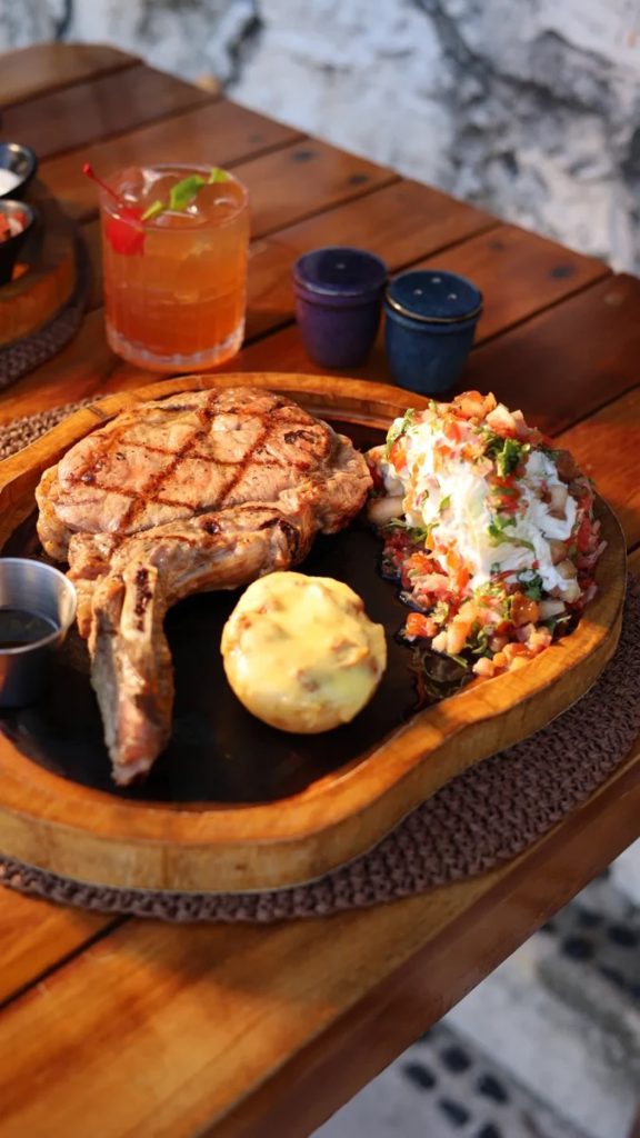 Plates crossing from the kitchen to tables under the palapa